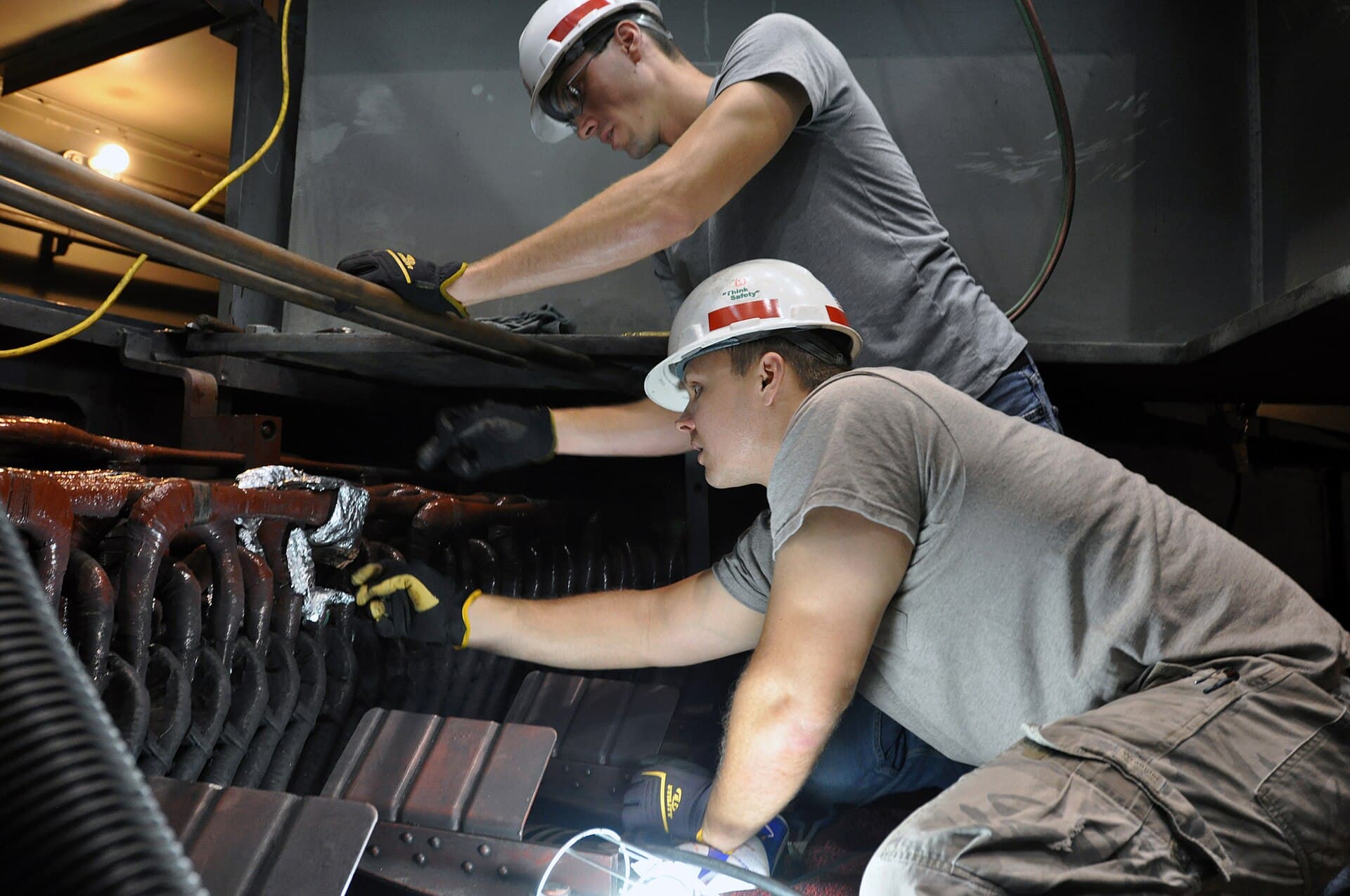 Licensed electricians working on electrical equipment with tools and meters