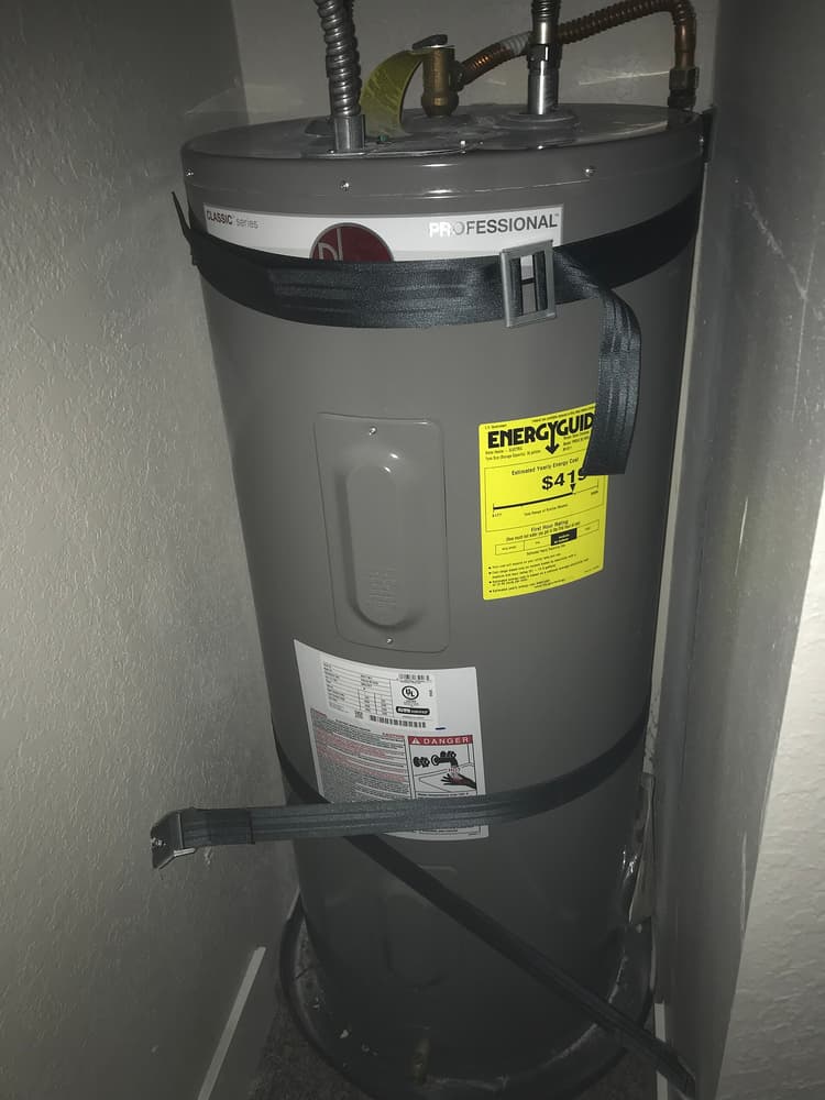 A Rheem electric storage water heater in a service cupboard